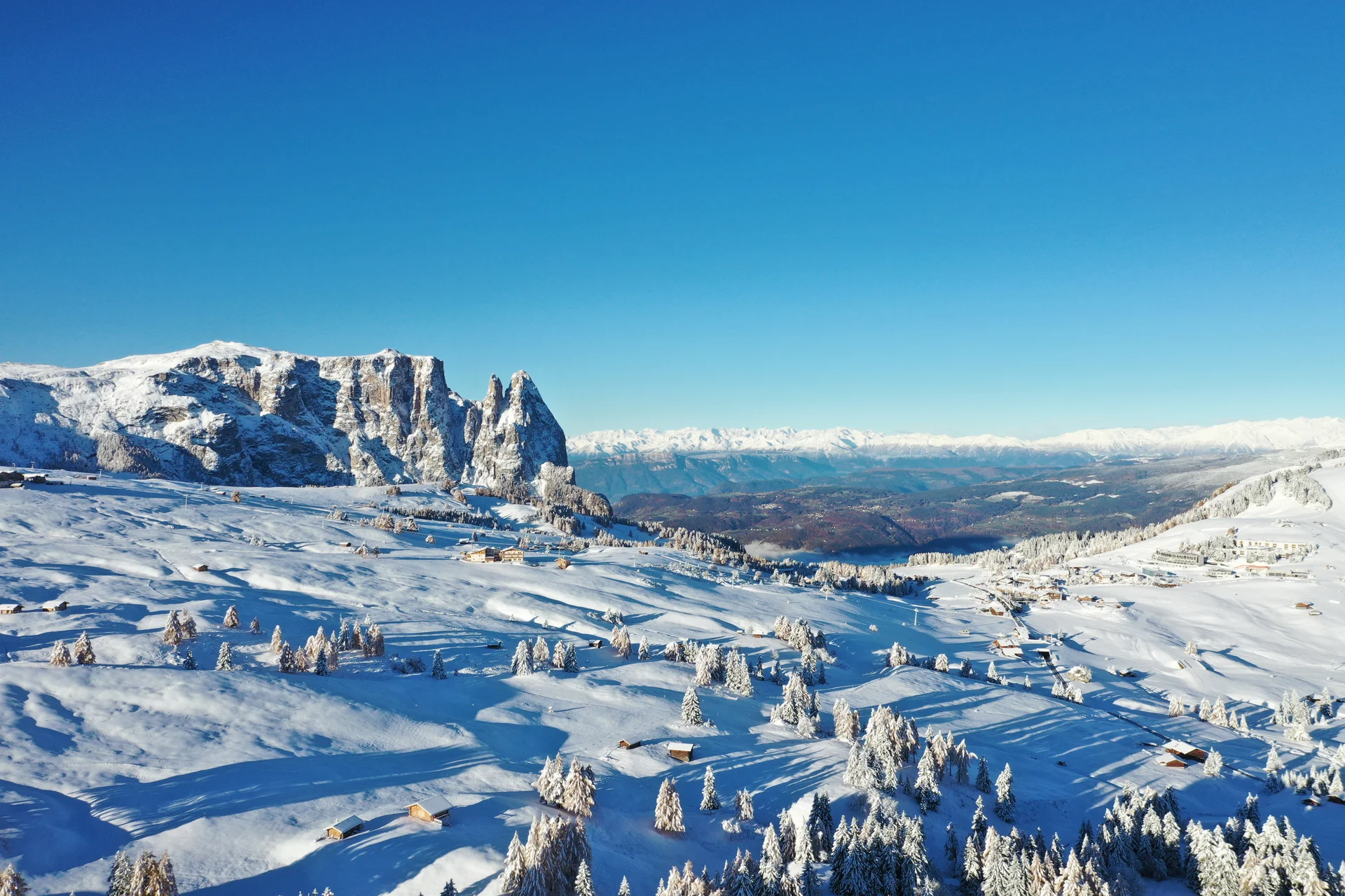 Verschneite Alpenlandschaft mit klar blauem Himmel und Tannenbäumen